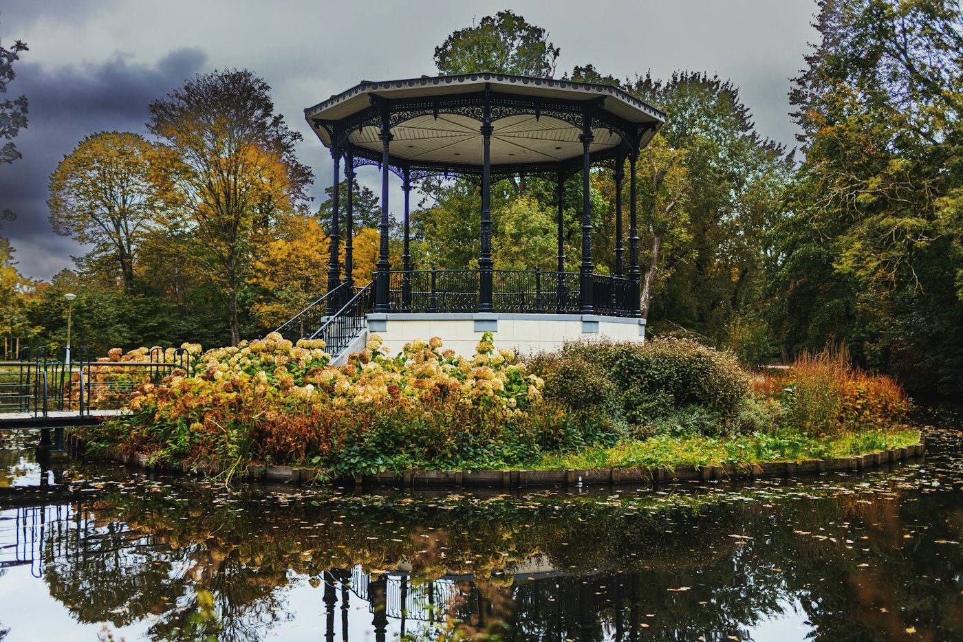 Octagonal bandstand by a pond in an autumn park